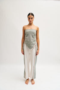 Front image of cream and khaki cotton trousers featuring a wide-leg, relaxed fit with a linen-style drape.